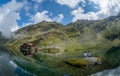 Balea lake and Balea Hotel in spring time with clouds Royalty Free Stock Photo